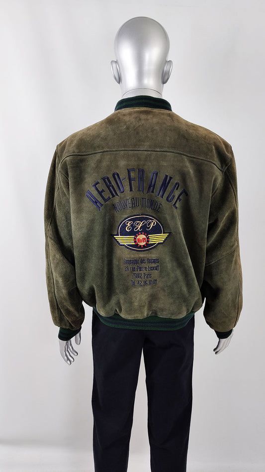 A mannequin wearing a vintage green real suede bomber jacket from the 1980s from Zeus Vintage. It has aviator style embroidery on the back.