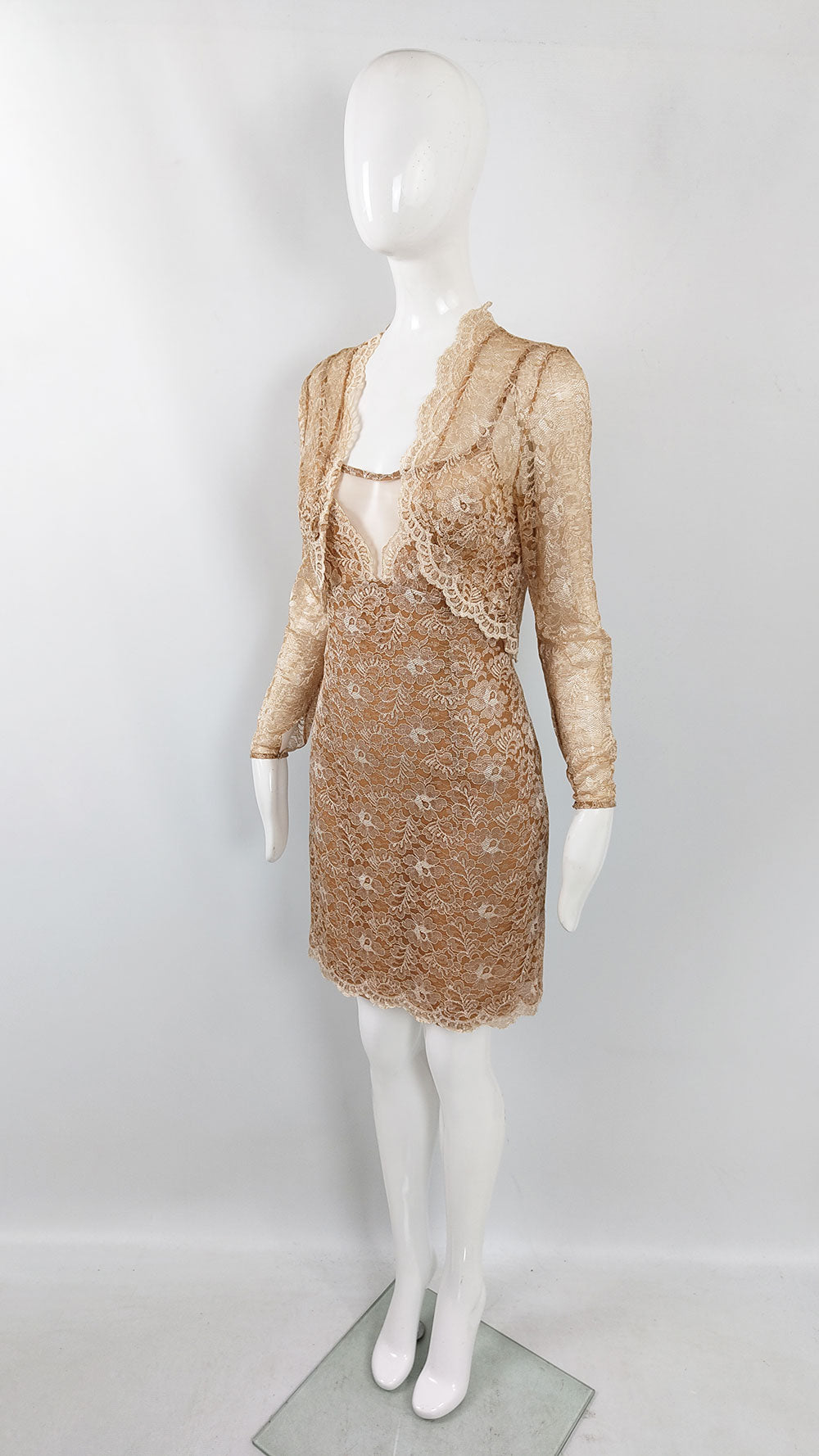 A vintage cocktail dress and shrug ensemble in a tan lace with a matching sheer jacket.