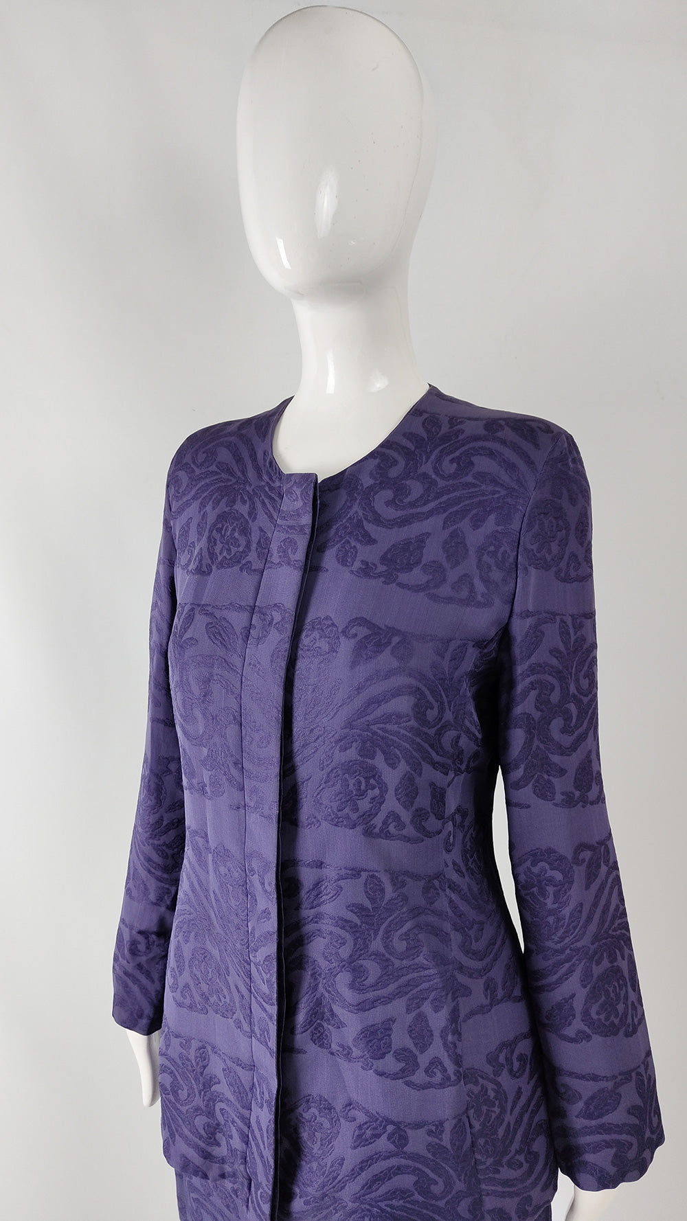 Purple patterned dress on a mannequin against a white background