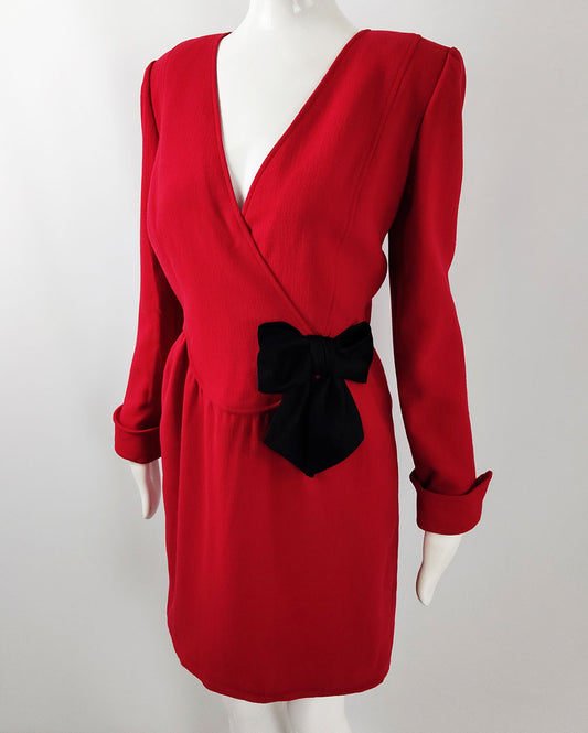 A vintage 1980s deep red evening dress by Oscar de la Renta with long sleeves, a deep neckline and a bow to the waist.