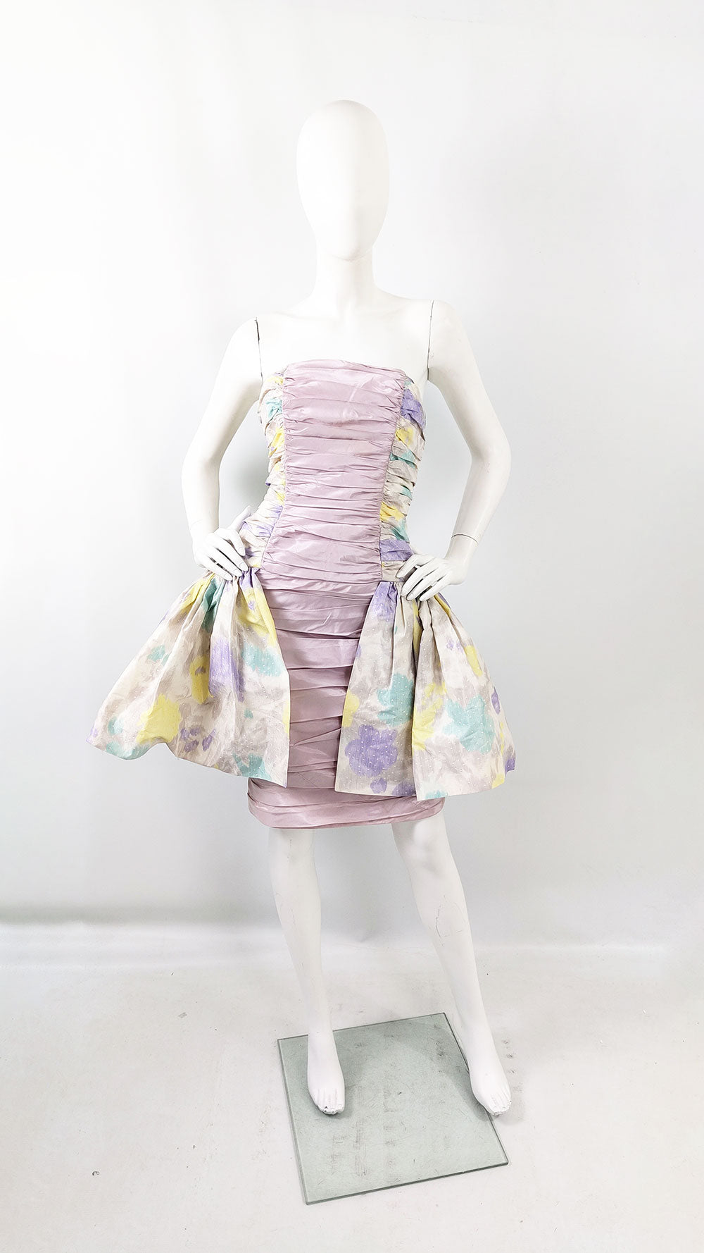 An image of a mannequin wearing a vintage 80s jacques azagury prom dress with a full peplum skirt.