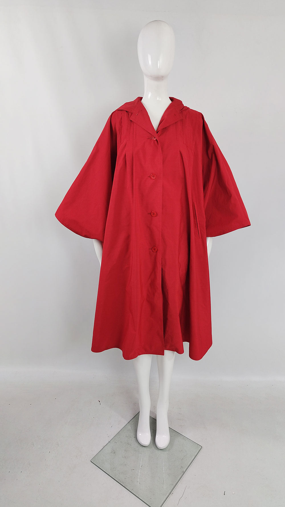 A 1970s vintage cape coat by Bill Haire for Neiman Marcus in a bright red with wide sleeves.