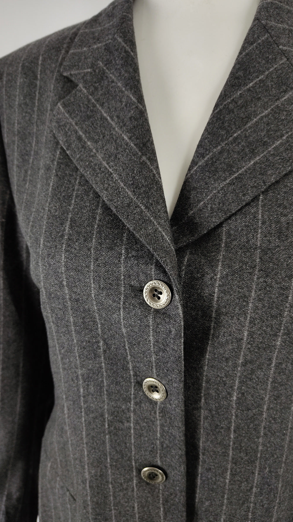 A grey womens vintage blazer from the 1990s with shoulder pads and a nipped waist.