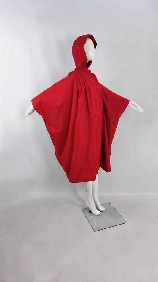 An image of a mannequin wearing a vintage red cape with a hood and sleeves from the 1970s.