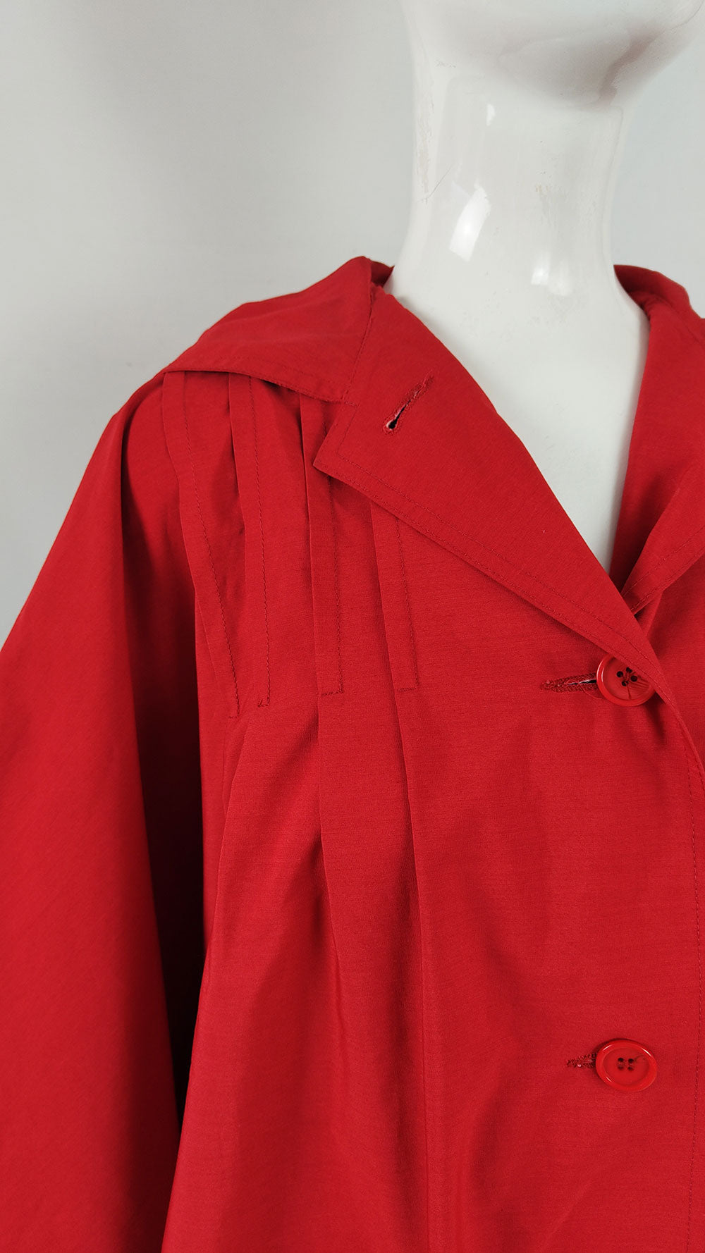 A close-up of pleated shoulders on a vintage Bill Haire red cape.