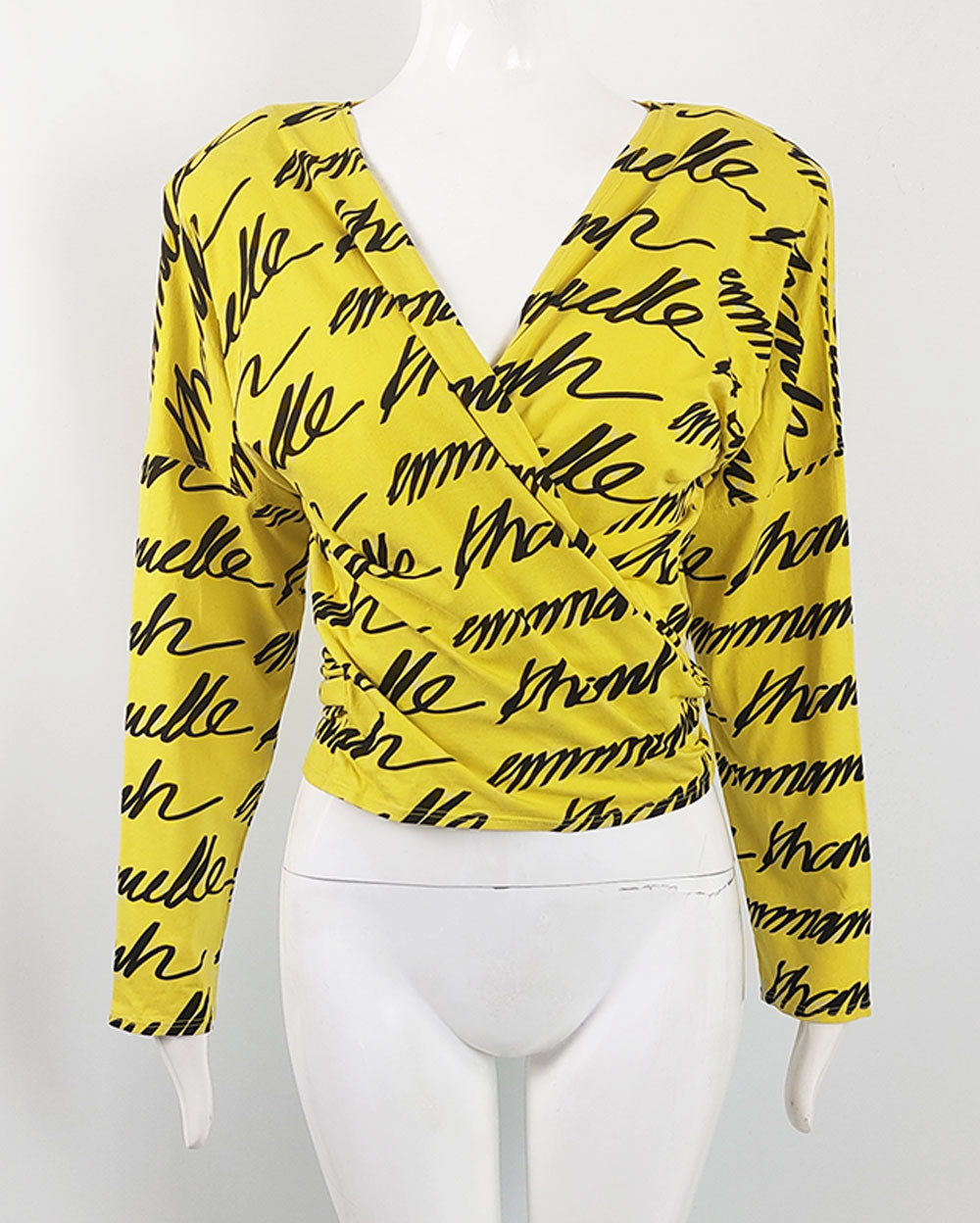 A vintage emmanuelle khanh top from the 80s in a yellow and black cotton jersey with a wrap front and long sleeves.
