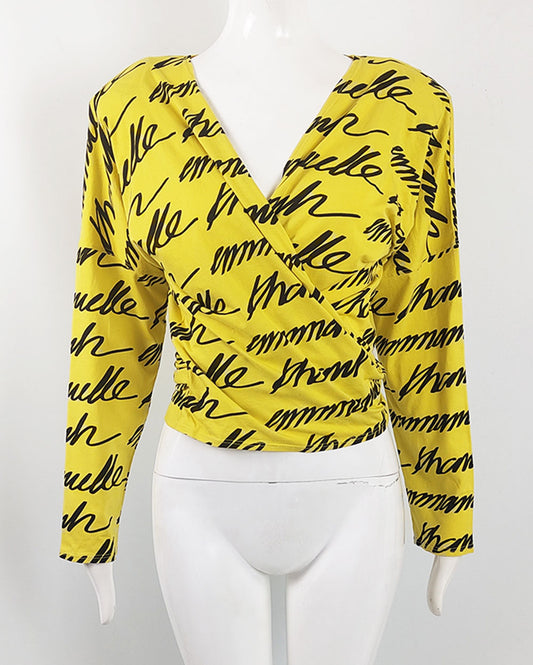 A vintage emmanuelle khanh top from the 80s in a yellow and black cotton jersey with a wrap front and long sleeves.